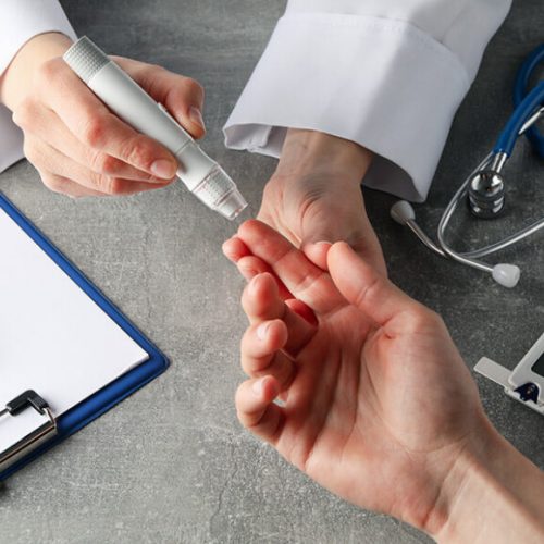 doctor-checking-blood-sugar-level-in-patient-diabetes-on-gray-table-850x580